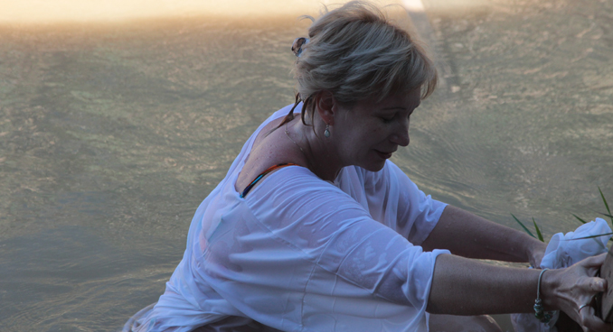 A Russian woman immerse herself in the waters of the Bethany Beyond Jordan baptismal site, photo courtesy Mac Lacy
